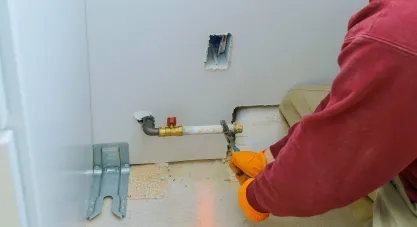 A plumber working on a gas line, connecting pipes with tools