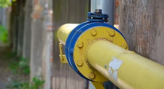 A yellow gas pipe section featuring a blue flanged connection and valve
