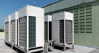 Multiple white multi-zone HVAC outdoor units lined up on a rooftop